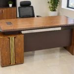 Executive office desk with three-drawer pedestal and wood-grain finish.