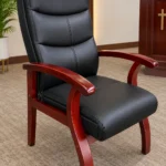 Black upholstered pastor's chair with polished wooden frame and armrests