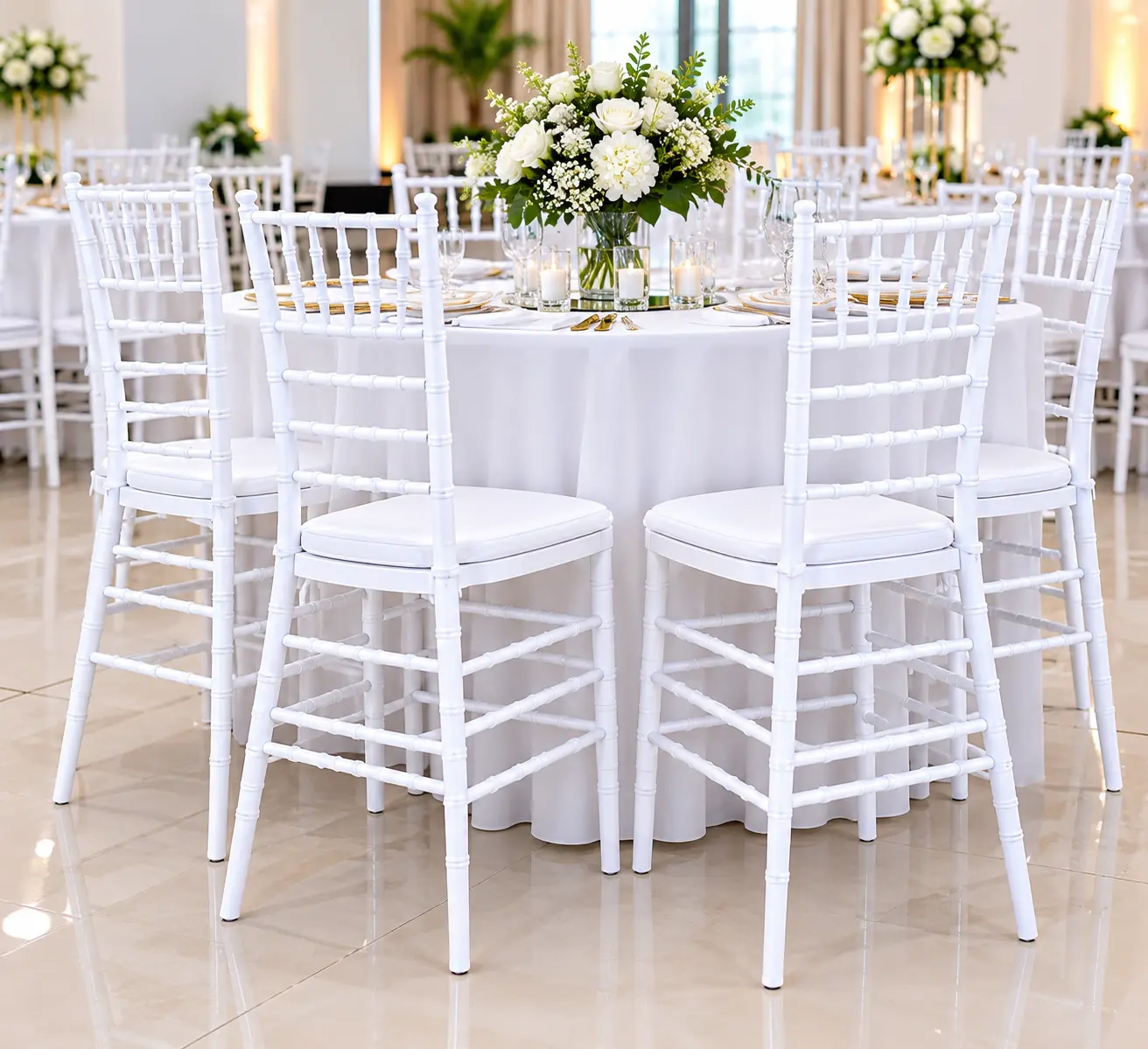 White Chiavari banquet chairs arranged around a table at an elegant wedding reception.